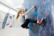 © Flamingo Images - Girl climbing on a wall in bouldering gym