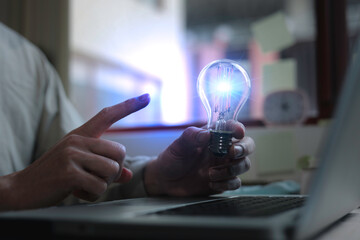 businessman hand holding creative light bulb with power line technology, analysis solution and devel