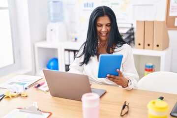 Sticker - Middle age hispanic woman business worker using touchpad and laptop at office