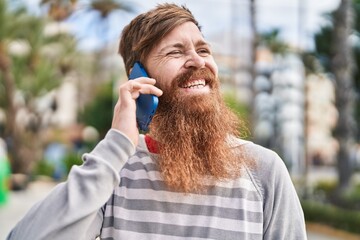 Sticker - Young redhead man smiling confident talking on the smartphone at street