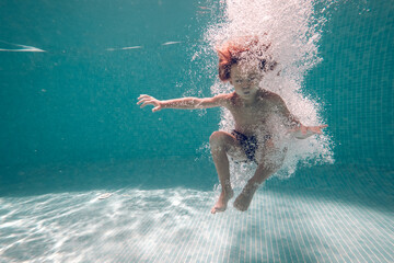 Underwater shot of boy jumping in pool