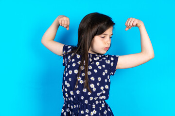 Caucasian kid girl wearing floral dress over blue background  winking looking at the camera with sexy expression, cheerful and happy face.