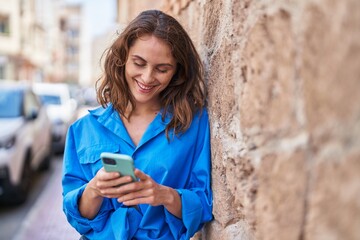 Sticker - Young woman smiling confident using smartphone at street