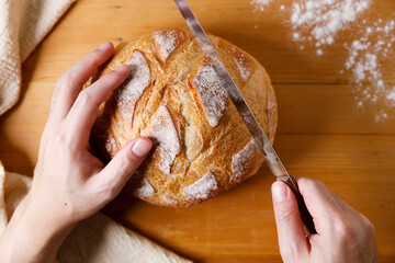 Closeup of rustic bread loaf on wooden table.