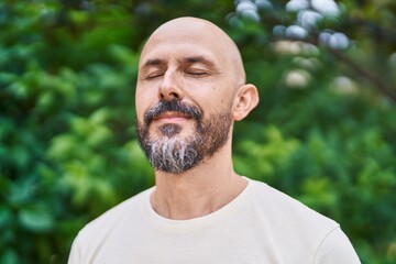 Poster - Young bald man breathing with closed eyes at park