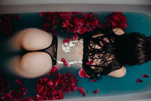 Young Girl With A Sexy Ass In Beautiful Underwear Lies In A Bath With Peony Flowers