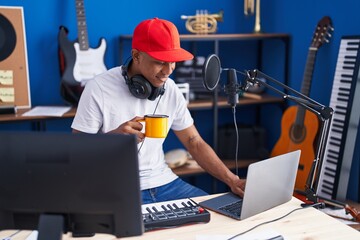 Poster - Young latin man musician having dj session drinking coffee at music studio