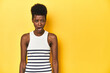 © Asier - Vibrant African woman, white tank-top, yellow studio, shouting very angry, rage concept, frustrated.