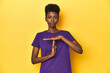 © Asier - African woman in violet tee, yellow studio scene, showing a timeout gesture.