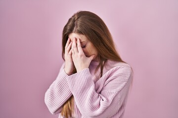 Sticker - Young caucasian woman standing over pink background with sad expression covering face with hands while crying. depression concept.