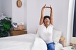 © Krakenimages.com - African american woman waking up stretching arms at bedroom