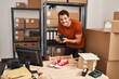 © Krakenimages.com - Young hispanic man ecommerce business worker make photo to sneakers at office
