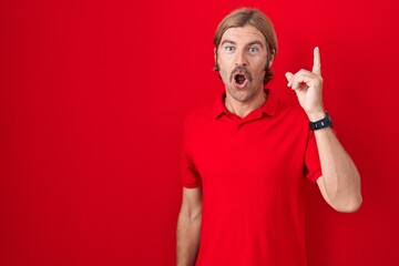 Sticker - Caucasian man with mustache standing over red background pointing finger up with successful idea. exited and happy. number one.