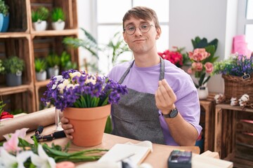 Poster - Caucasian blond man working at florist shop doing money gesture with hands, asking for salary payment, millionaire business