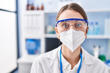 Poster - Young caucasian woman scientist wearing medical mask at laboratory