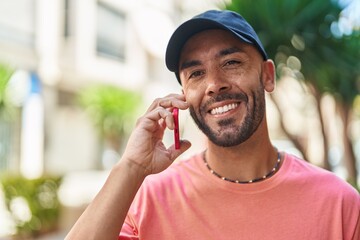 Sticker - Young bald man smiling confident talking on the smartphone at street