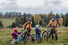 Young Family With Little Children At Bicycles, In The Middle Of Autumn Nature.Concept Of A Healthy Lifestyle.