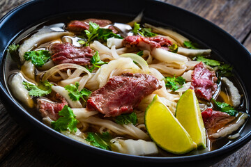 Sticker - Pho soup - Vietnamese soup with beef on wooden table
