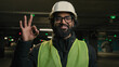 © Yuliia - Happy Indian technician contractor mechanic in hardhat helmet showing ok gesture parking lot recommend okay sign factory work Arabian man worker manufacture engineer in hard hat heavy metal industry