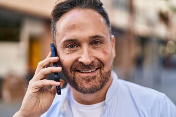 Poster - Young caucasian man smiling confident talking on the smartphone at street