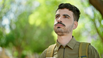 Sticker - Young hispanic man tourist wearing backpack with relaxed expression at park