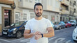 © Krakenimages.com - Young hispanic man pointing watch at street