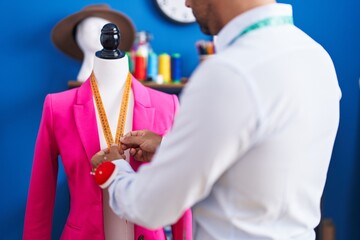 Sticker - Young hispanic man tailor measuring jacket at sewing studio