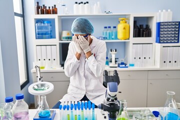 Poster - Brunette woman working at scientist laboratory with sad expression covering face with hands while crying. depression concept.