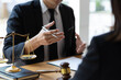 © Wasan - Lawyer is explaining the terms of the legal contract document and asking the client to sign it properly. Legal counsel and legal proceedings consulting services.