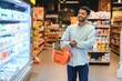 Portrait of indian man purchasing in a grocery store. Buying grocery for home in a supermarket