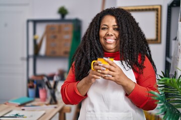 Canvas Print - African american woman artist smiling confident drinking coffee at art studio