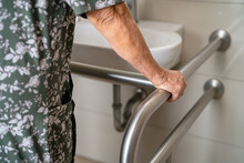 Asian Elderly Woman Patient Use Toilet Bathroom Handle Security In Nursing Hospital, Healthy Strong Medical Concept.