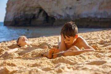 Poster - Child, tickling sibling on the beach on the feet with feather, kid cover in sand, smiling, laughing