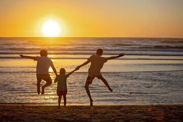 Canvas Print - Happy children, boys, playing on the beach on sunset, kid cover in sand, smiling, laughing