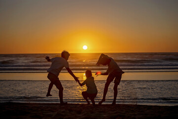 Canvas Print - Happy children, boys, playing on the beach on sunset, kid cover in sand, smiling, laughing