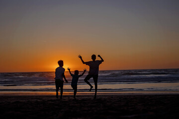 Sticker - Happy children, boys, playing on the beach on sunset, kid cover in sand, smiling, laughing