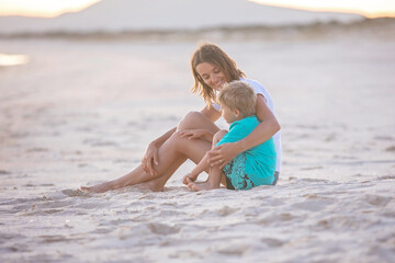 Sticker - Happy children, boys, playing on the beach on sunset, kid cover in sand, smiling, laughing