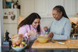 © Sabrina - Happy african mother and daughter preparing fresh cake in the morning inside house kitchen