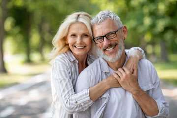 happy mature spouses. portrait of older couple hugging and smiling at camera