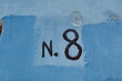 N. 8. Numéro huit. inscription peinte en noir sur mur bleu.