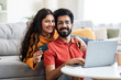 © Prostock-studio - Internet Purchases. Portrait Of Smiling Indian Couple With Laptop And Credit Card
