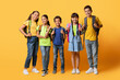 © Prostock-studio - happy boys and girls posing with backpacks posing on yellow
