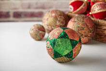 Patchwork Puzzle Balls And Christmas Decorations In Basket On Brick Wall Background