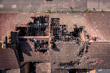 Wall Mural - Aerial view directly above the damaged roof of derelict terraced houses after a house fire