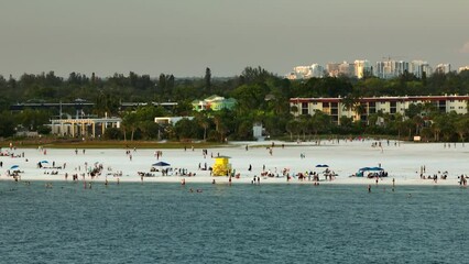 Wall Mural - High angle view of crowded Siesta Key beach in Sarasota, USA. Many people enjoing vacations time swimming in ocean water and relaxing on warm Florida sun at sundown