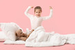 © Pixel-Shot - Little girl with soft blanket waking up on pink background