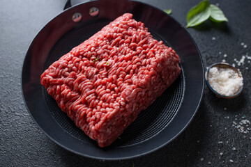 Wall Mural - Minced meat on pan on dark background