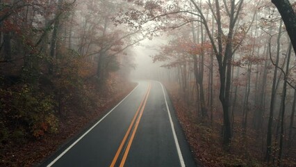 Wall Mural - Foggy and moody aerial drone over misty mountain road during  autumn in Ozark mountains of Arkansas 