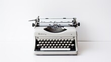 A Vintage Typewriter Sitting On A White Background.