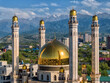 A beautiful mosque with golden domes in the Kazakh city of Almaty against the backdrop of mountains on a summer day